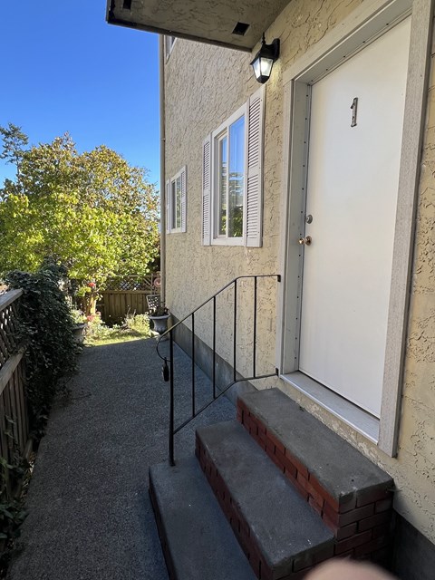 A white door with a number 1 on it is on the right side of a house.